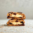 Stack of chocolate chip cookies with cream filling on a light surface